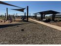 Community playground with sunshades and a picnic shelter with tables for residents and their guests at 15781 W Cheryl Dr, Waddell, AZ 85355