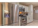 Modern kitchen featuring stainless steel appliances, white cabinets, and ample counter space at 1749 E Medlock Dr, Phoenix, AZ 85016