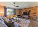 Bright living room featuring wood paneling, ceiling fan, a large window and comfortable couches at 1749 E Medlock Dr, Phoenix, AZ 85016