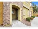 Condo entrance featuring an arched doorway and unit number 105, with neatly landscaped surroundings at 18250 N Cave Creek Rd # 105, Phoenix, AZ 85032