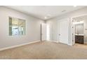 Spacious carpeted bedroom with large windows, a walk-in closet, and ensuite bathroom access at 18742 N 269Th Ln, Buckeye, AZ 85396