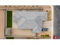 Aerial view of a home featuring grey tiled roof, desert landscaping, a small green lawn and a covered patio at 2013 E Brooklyn Dr, Casa Grande, AZ 85122