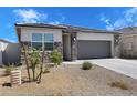 Attractive single-story home showcasing stone accents, desert landscaping, and a two-car garage at 24220 W Ripple Rd, Buckeye, AZ 85326