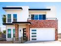 Modern two-story home with brick accents, a balcony, and a two-car garage at 2441 W Morten Ave, Phoenix, AZ 85021