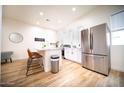 Modern kitchen with stainless steel appliances, white cabinets, and a breakfast bar with seating at 2441 W Morten Ave, Phoenix, AZ 85021