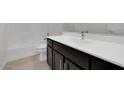 Well-lit bathroom featuring a dark vanity with white countertop, modern fixtures, and a tiled shower-tub combination at 2524 N Pony Ln, Casa Grande, AZ 85122