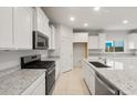 Modern kitchen with stainless steel appliances, white cabinets, and granite countertops at 2649 N Riverside Dr, Florence, AZ 85132