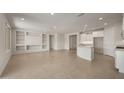 Bright and airy living room with tile flooring, built-in shelves, and large windows offering ample natural light at 26957 W Lone Cactus Dr, Buckeye, AZ 85396