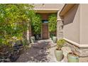 Welcoming front entrance with stone accents, potted plants, and decorative water feature at 27582 N 67Th Way, Scottsdale, AZ 85266