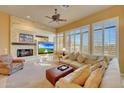 Cozy living room with a stone fireplace, built-in entertainment center, and plantation shutters at 3109 W Summit Walk Ct, Anthem, AZ 85086