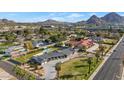 Expansive aerial view featuring a home with lush landscaping, a large pool, and mountain scenery at 3702 E Camelback Rd, Phoenix, AZ 85018