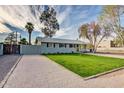 Charming single-story home with a well-manicured lawn, mature trees, and a long driveway at 4112 N 11Th St, Phoenix, AZ 85014