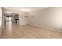 Spacious living room featuring tile floors, neutral walls, and modern light fixture at 46072 W Barbara Ln, Maricopa, AZ 85139