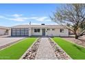 Beautiful single-story home featuring desert landscaping, brick walkway, and modern garage door at 5927 E Edgemont Ave, Scottsdale, AZ 85257