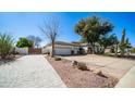 Spacious home with brick driveway, desert landscaping, and mature shade trees at 737 E Boston St, Gilbert, AZ 85295