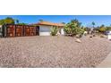 Side view of the house featuring a barrel tile roof, desert landscape, and a fenced-in yard at 9234 N 33Rd Way, Phoenix, AZ 85028