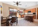 Eat-in kitchen featuring wooden cabinets, granite countertops, an island, and access to the backyard at 11489 N 141St St, Scottsdale, AZ 85259