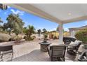 Inviting covered patio with comfortable seating and views of the tranquil lake at 15563 W Roanoke Ave, Goodyear, AZ 85395