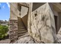 Exterior stairs leading to the condo entrance with stone accents and stucco walls at 16800 E El Lago Blvd # 2072, Fountain Hills, AZ 85268