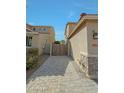 View of long driveway made of pavers and gated access to the property and backyard at 16881 W Monroe St, Goodyear, AZ 85338