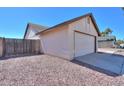 Side view of the home showcasing the attached two-car garage and fenced yard at 1753 E Shasta St, Casa Grande, AZ 85122