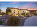 Beautiful home displaying desert landscaping with rocks, plants, and a stone walkway at 19051 N 259Th Ave, Buckeye, AZ 85396