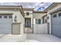 Close-up of home entrance with front gate between two garage doors, and elegant light fixtures at 19736 E Emperor Blvd, Queen Creek, AZ 85142