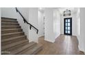 Bright entryway with tiled floors, staircase, modern light fixture, and paneling at 20979 E Mayberry Rd, Queen Creek, AZ 85142