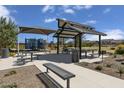 Picnic tables and shade structures sit near a playground in the Queen Creek community at 21141 E Canary Way, Queen Creek, AZ 85142