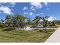 Community playground features picnic benches and seating areas with shade structures and mature trees at 21141 E Canary Way, Queen Creek, AZ 85142