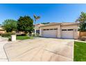 Front view of the 3-car garage and driveway of this single-Gathering home at 22139 N 80Th Ln, Peoria, AZ 85383