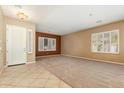 Spacious living room with tile entry, carpeted area, and plantation shutters at 22139 N 80Th Ln, Peoria, AZ 85383