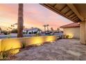 Beautiful outdoor patio area with stone pavers, desert landscaping, and beautiful outside lighting at 2415 Leisure World --, Mesa, AZ 85206