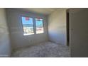 Empty bedroom under construction, with grey walls, a window, and concrete floor at 2707 E Abe Truckle Ave, San Tan Valley, AZ 85140