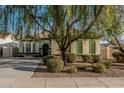 Charming single-story home featuring a mature tree in the landscaped front yard at 3080 E Palmdale Ln, Gilbert, AZ 85298