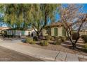 Charming single-story home featuring a mature tree in the landscaped front yard at 3080 E Palmdale Ln, Gilbert, AZ 85298