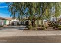 Charming single-story home featuring a mature tree in the landscaped front yard at 3080 E Palmdale Ln, Gilbert, AZ 85298