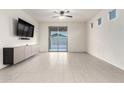 Bright living room featuring tile flooring, a sliding glass door, and a modern ceiling fan at 3225 W Fremont Rd, Phoenix, AZ 85041