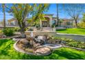 Stately home featuring a stone waterfall, manicured lawn, and a grand entrance with double doors at 4201 E Claremont Ave, Paradise Valley, AZ 85253