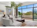 Living room features an oversized window, stylish furnishings, and seamless indoor-outdoor flow to a private balcony at 4201 E Claremont Ave, Paradise Valley, AZ 85253