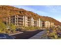 Modern condominiums nestled against a hillside with desert landscaping, private balconies, and a convenient parking area at 5000 N Camelback Ridge Rd # 410, Scottsdale, AZ 85251