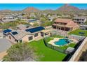 Aerial view of a home's backyard featuring a private pool, landscaped yard, and solar panels on the roof at 6603 W Via Dona Rd, Phoenix, AZ 85083