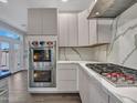 Contemporary kitchen with stainless steel oven, gas cooktop, and white marble countertops providing an elegant cooking experience at 6603 W Via Dona Rd, Phoenix, AZ 85083