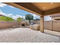 Private backyard featuring a covered patio, fireplace, and outdoor kitchen area at 9165 W Mine Trl, Peoria, AZ 85383