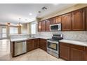 Bright kitchen with stainless steel appliances, wooden cabinets, and backsplash at 9165 W Mine Trl, Peoria, AZ 85383