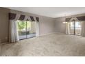 Expansive living room featuring neutral walls and large windows that offer access to outdoor balconies at 9455 E Raintree Dr # 2032, Scottsdale, AZ 85260