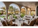 Spacious outdoor living room features plush seating, decorative rug, and views of the manicured lawn at 9820 E Thompson Peak Pkwy # 841, Scottsdale, AZ 85255