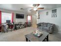 Spacious living room featuring large windows, a ceiling fan, comfortable seating, and plenty of natural light at 1030 E Desert Moon Trl, San Tan Valley, AZ 85143