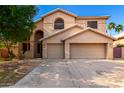 Two-story home featuring a two-car garage, neutral colors, and desert landscaping at 10452 E Florian Ave, Mesa, AZ 85208