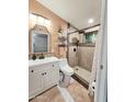 Updated bathroom with a modern vanity, decorative mirror, and a walk-in shower with tiled walls at 10624 W Oakmont Dr, Sun City, AZ 85351